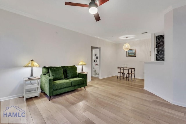 sitting room featuring light hardwood / wood-style flooring, ornamental molding, and ceiling fan