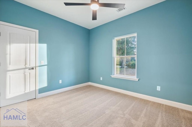 carpeted spare room featuring ceiling fan