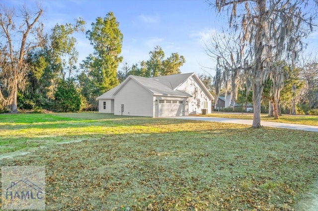 view of side of home featuring a lawn and a garage