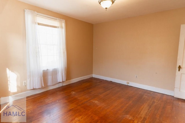 unfurnished room featuring wood-type flooring and baseboards