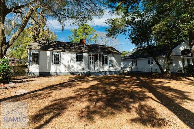 view of front of house with crawl space, fence, and a chimney