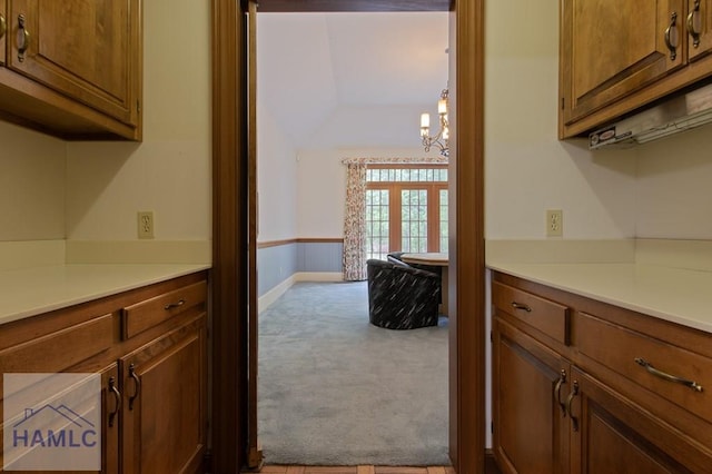 152 Lakeview Dr, Jesup, GA 31545 - kitchen featuring a chandelier, carpet flooring, light countertops, and brown cabinets