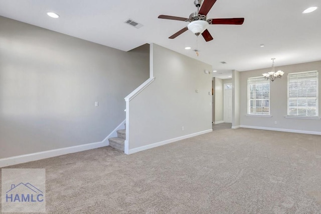 unfurnished living room with ceiling fan with notable chandelier and light carpet