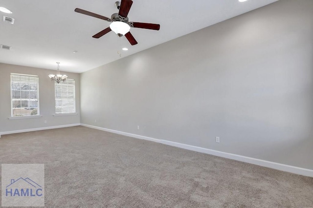 spare room with ceiling fan with notable chandelier and light carpet