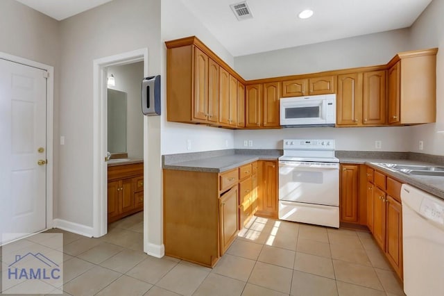 kitchen featuring white appliances, sink, and light tile patterned floors