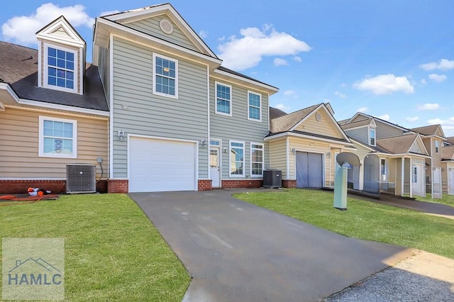 view of front of house with a garage, a front lawn, and central air condition unit