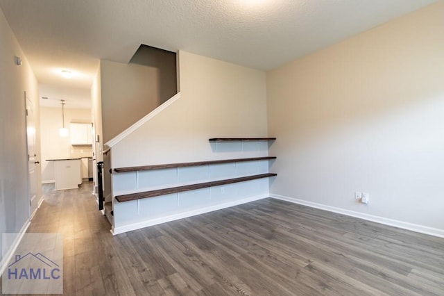 stairway with a textured ceiling and hardwood / wood-style flooring