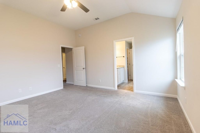 unfurnished bedroom with ceiling fan, ensuite bathroom, light carpet, and lofted ceiling