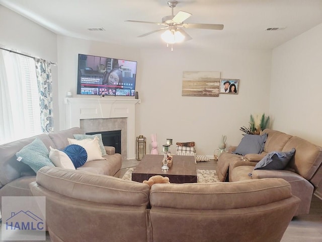 living room with hardwood / wood-style flooring, ceiling fan, and a fireplace