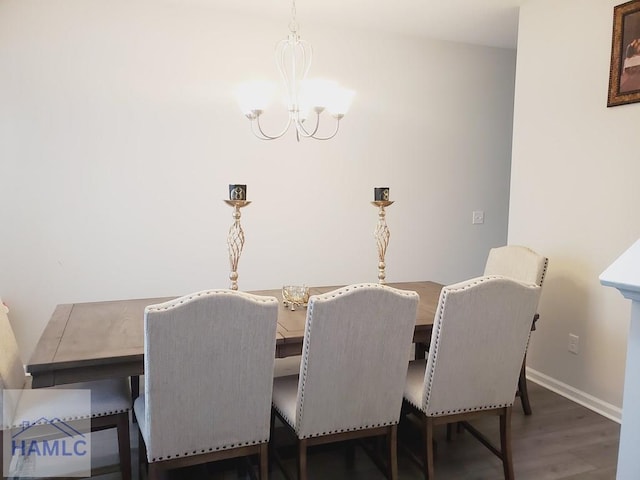 dining space featuring dark hardwood / wood-style flooring and a chandelier