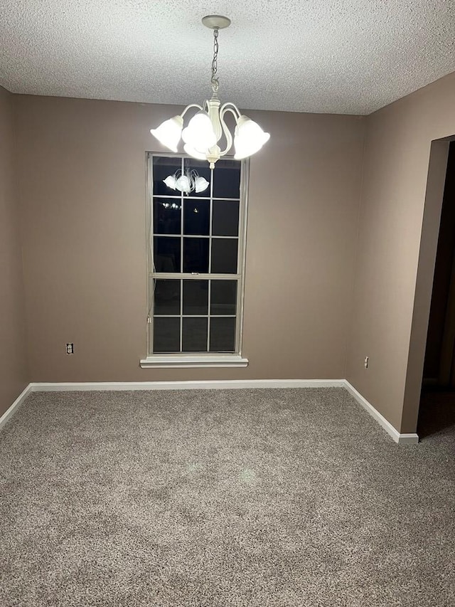 unfurnished room featuring carpet flooring, a textured ceiling, and an inviting chandelier