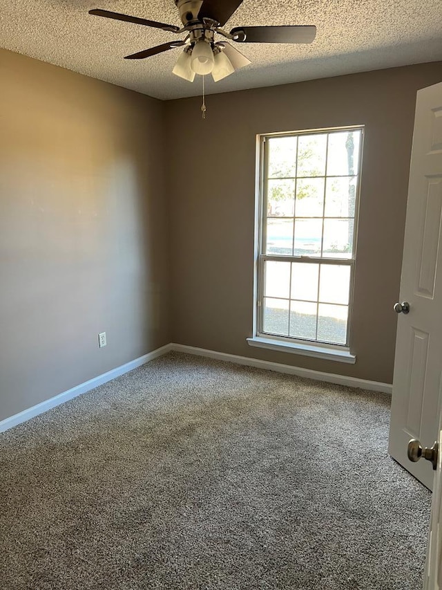 carpeted empty room with ceiling fan and a textured ceiling