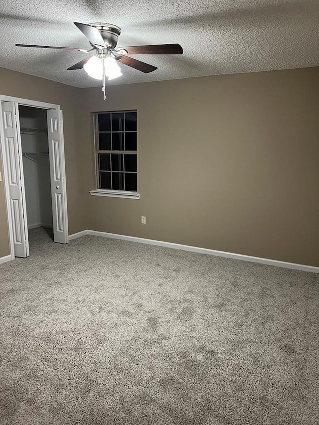 unfurnished bedroom featuring ceiling fan, a closet, carpet floors, and a textured ceiling