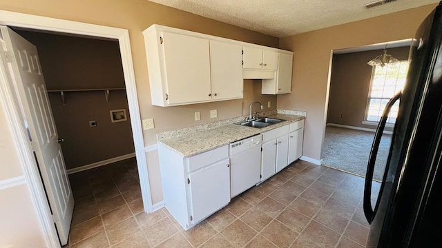 kitchen featuring dishwasher, black refrigerator, sink, white cabinetry, and a chandelier