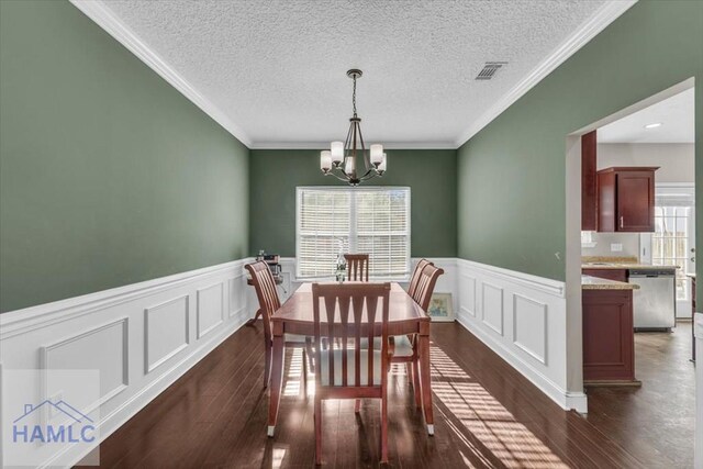 732 Waterlily Ct, Hinesville, GA 31313 - dining area with an inviting chandelier, a decorative wall, wainscoting, dark wood-style flooring, and visible vents