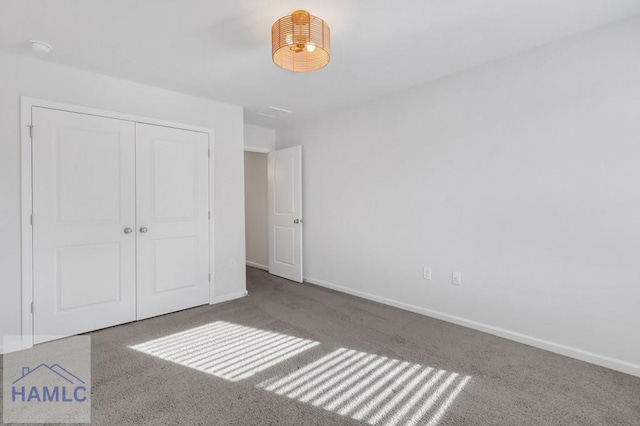 unfurnished bedroom featuring a closet, baseboards, and carpet flooring