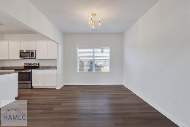 kitchen featuring stainless steel appliances, dark wood-type flooring, dark countertops, and white cabinetry