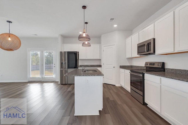 kitchen featuring an island with sink, appliances with stainless steel finishes, and white cabinets