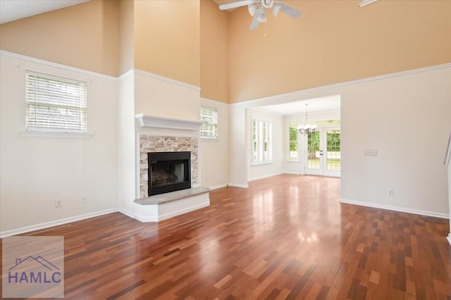 301 Marsh View Dr, Richmond Hill, GA 31324 - unfurnished living room featuring a ceiling fan, a high ceiling, a stone fireplace, a chandelier, and wood finished floors