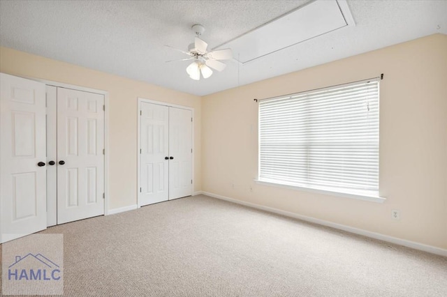 301 Marsh View Dr, Richmond Hill, GA 31324 - unfurnished bedroom featuring multiple closets, carpet floors, attic access, ceiling fan, and a textured ceiling