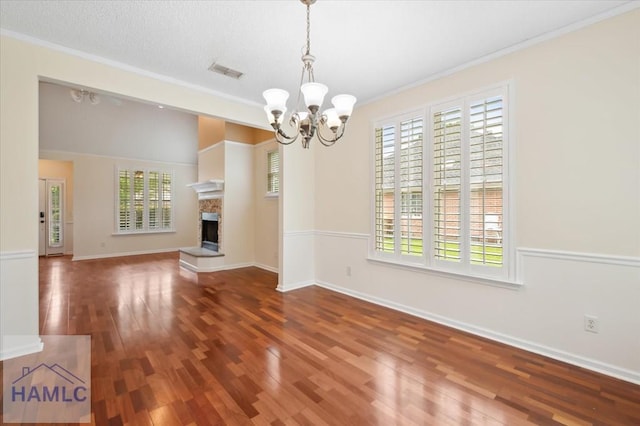 301 Marsh View Dr, Richmond Hill, GA 31324 - unfurnished dining area with plenty of natural light, a chandelier, ornamental molding, wood finished floors, and a fireplace with raised hearth
