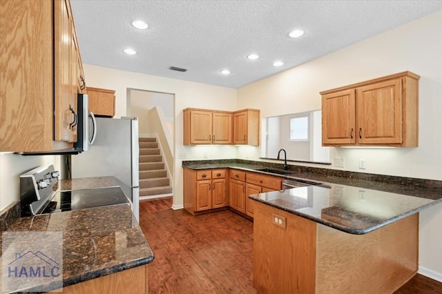 301 Marsh View Dr, Richmond Hill, GA 31324 - kitchen featuring electric range oven, dark wood-style floors, a peninsula, stainless steel microwave, and a textured ceiling