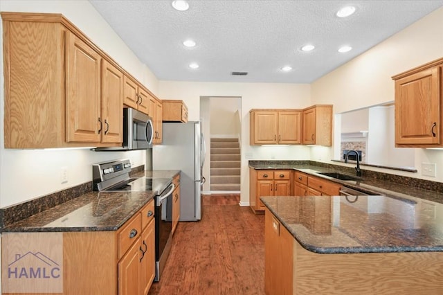 301 Marsh View Dr, Richmond Hill, GA 31324 - kitchen featuring appliances with stainless steel finishes, dark wood-style floors, recessed lighting, a textured ceiling, and dark stone counters