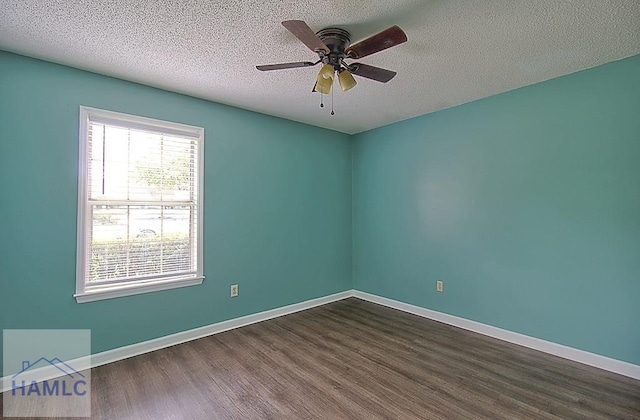 empty room featuring ceiling fan, dark wood-type flooring, and a textured ceiling