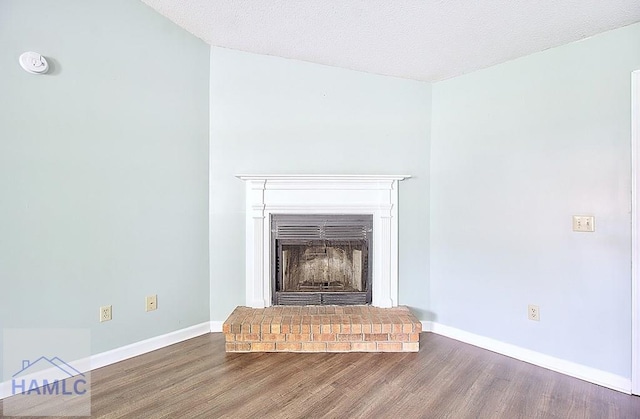 interior details with wood-type flooring, a textured ceiling, and a fireplace