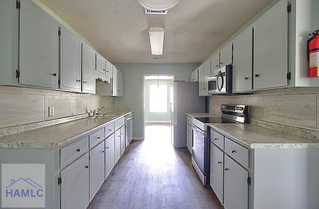 kitchen with appliances with stainless steel finishes, sink, and white cabinets