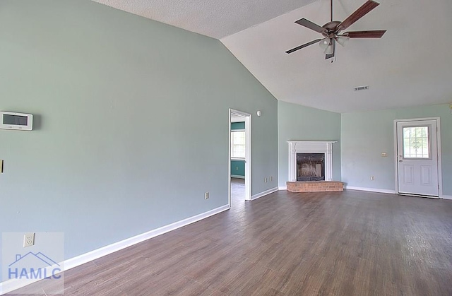 unfurnished living room featuring a brick fireplace, dark wood-type flooring, and a wealth of natural light