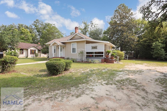 661 E Plum St, Jesup, GA 31546 - view of front of house featuring a chimney and a front lawn