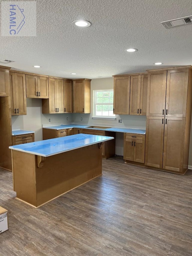 363 Sea Island Rd, Jesup, GA 31545 - kitchen featuring dark wood-style floors, a textured ceiling, a center island, recessed lighting, and brown cabinets