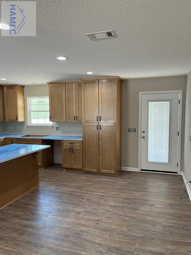 363 Sea Island Rd, Jesup, GA 31545 - kitchen with dark wood-style flooring, a textured ceiling, light countertops, brown cabinetry, and recessed lighting