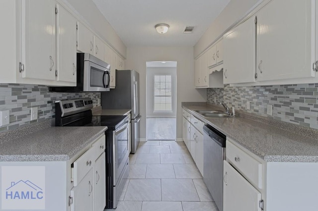 52 Pheasant Way, Hinesville, GA 31313 - kitchen with a sink, visible vents, backsplash, white cabinets, and appliances with stainless steel finishes