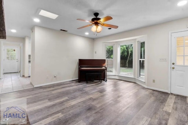 unfurnished room featuring a healthy amount of sunlight, visible vents, and wood finished floors