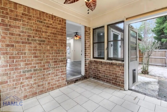 doorway to property with ceiling fan and fence