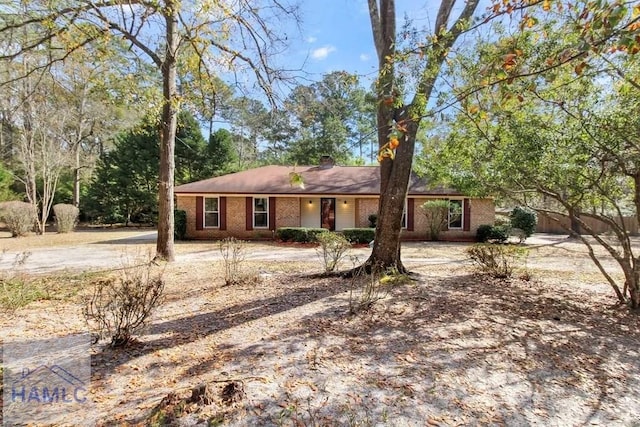 ranch-style home with brick siding and a chimney