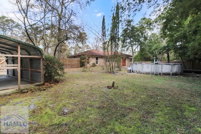 view of yard with fence and an outdoor pool