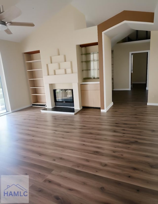 unfurnished living room with ceiling fan, dark hardwood / wood-style floors, lofted ceiling, and built in shelves