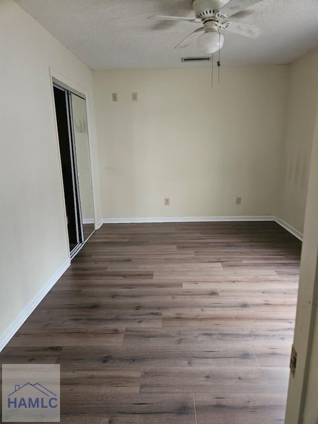 empty room featuring a textured ceiling, ceiling fan, and wood-type flooring