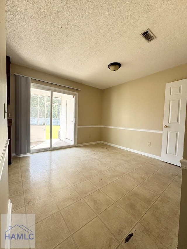 unfurnished room featuring a textured ceiling