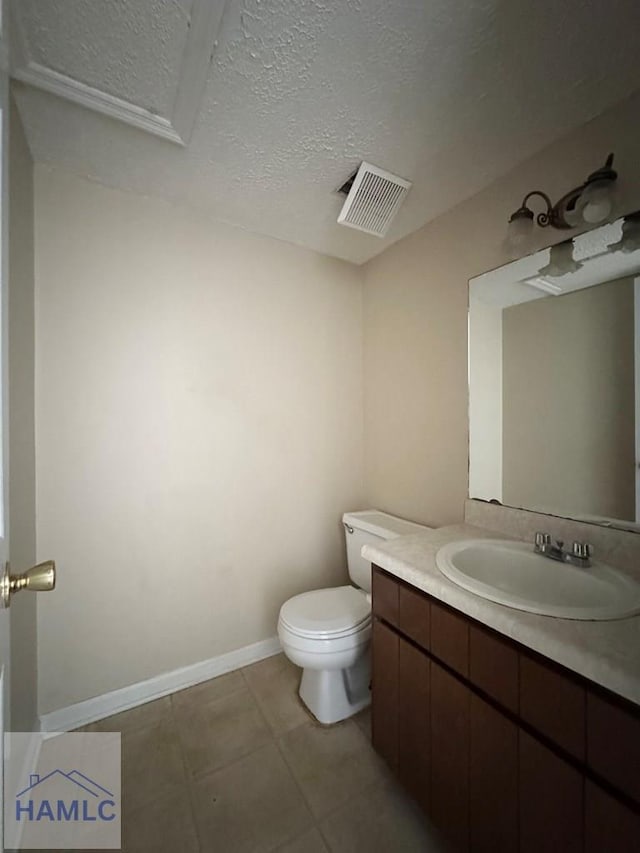 bathroom with tile patterned flooring, vanity, toilet, and a textured ceiling