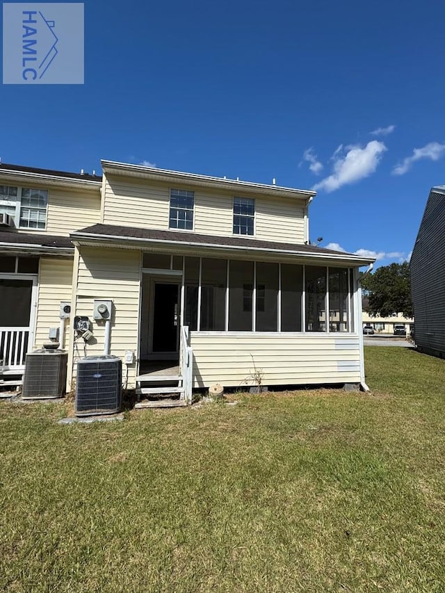 view of front of house featuring a sunroom, central AC unit, and a front yard