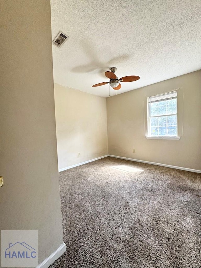 empty room featuring ceiling fan, carpet, and a textured ceiling