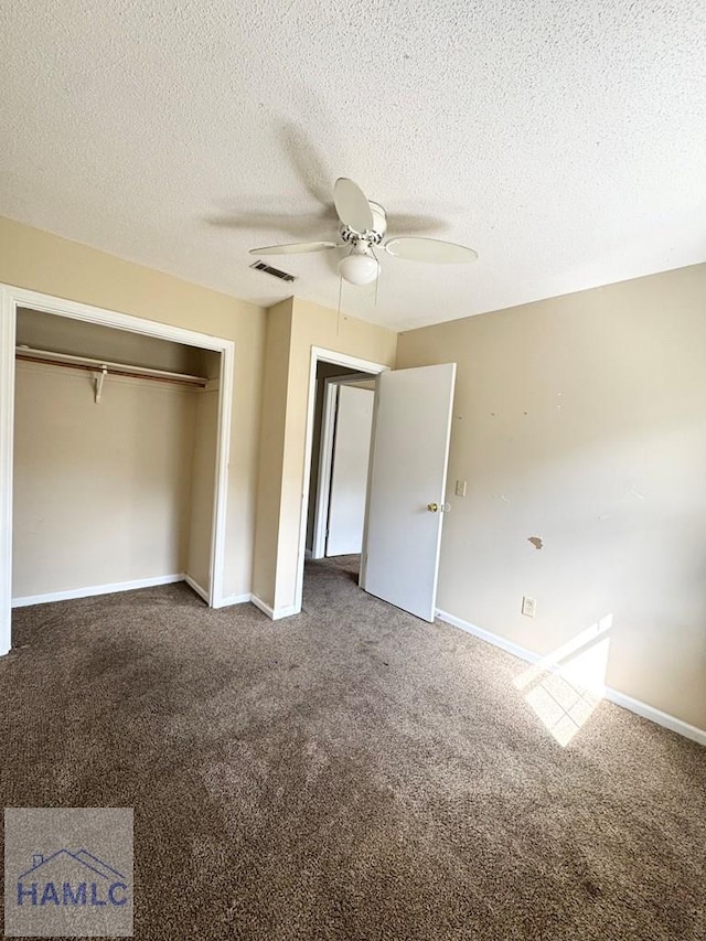 unfurnished bedroom featuring ceiling fan, a closet, carpet floors, and a textured ceiling