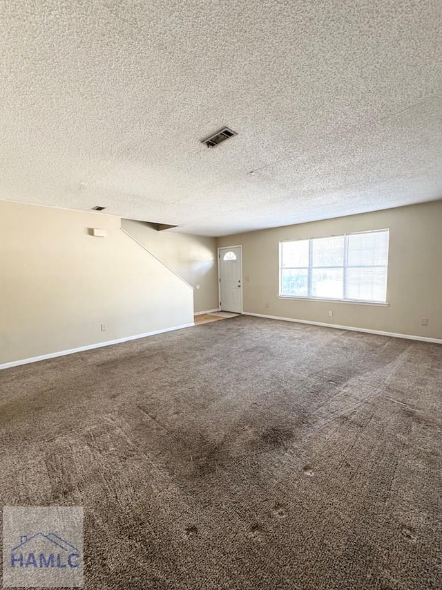 carpeted spare room featuring a textured ceiling