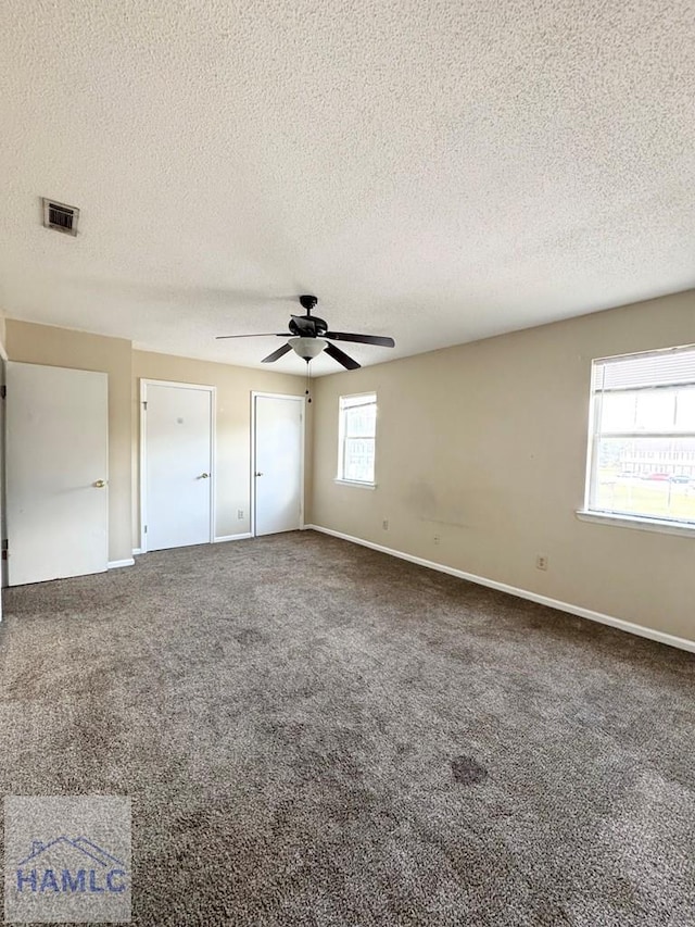 unfurnished bedroom featuring carpet, ceiling fan, and a textured ceiling