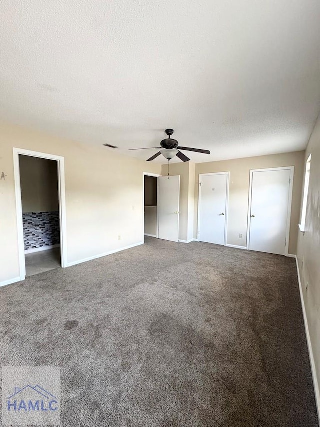 unfurnished bedroom featuring carpet, ceiling fan, and a textured ceiling