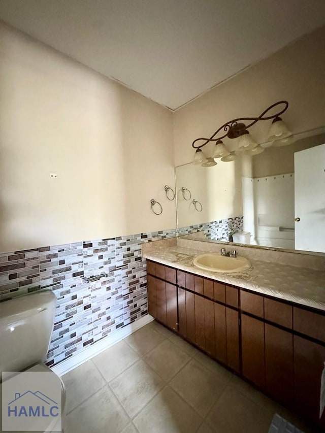 bathroom with backsplash, tile patterned flooring, vanity, and toilet